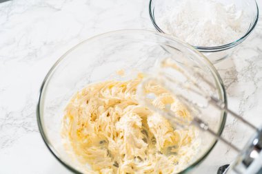 Lezzetli bir ikram yaratmak için, ev yapımı krem peynir kreması yapma süreci mükemmel bir doku ve tat elde etmek için kremalı malzemeleri çırpmayı içerir..