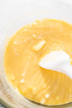 Çikolata parçacıkları ve diğer malzemeleri kaynayan suyun üzerine karıştırıp yumurta likörü hazırlıyorum..