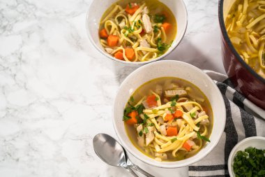 Beyaz seramik çorba kaselerinde kluski şehriyeli tavuk çorbası servis ediyorum..