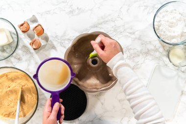 Silikon bir fırça kullanarak, metal demet kek tavası eritilmiş sebze kısaltmasıyla yağlanır, nefis havuçlu kek pişirmeye hazırlanır..