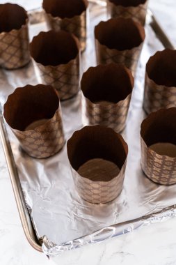 Paskalya ekmeği pişirmek için ekmek hamurunu kağıt kalemin içine karıştırmak..