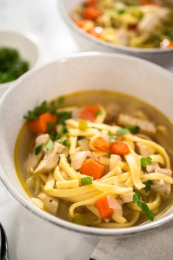 Beyaz seramik çorba kaselerinde kluski şehriyeli tavuk çorbası servis ediyorum..