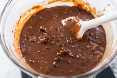 Çikolata parçacıkları ve diğer malzemeleri kaynayan suyun üzerinde karıştırarak çikolatalı şekerleme ve fıstık ezmesi karışımı hazırlıyorum..