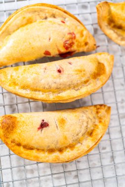 Mutfak tezgahındaki tavada taze pişmiş vişneli börek var..