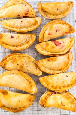 Mutfak tezgahındaki tavada taze pişmiş vişneli börek var..