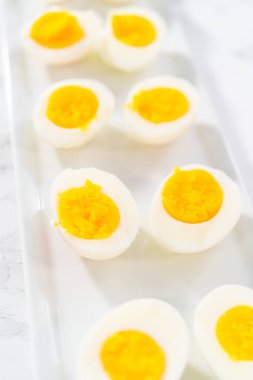 Beyaz servis tabağında dilimlenmiş haşlanmış yumurta..