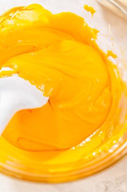 Erimiş çikolataya turuncu ve sarı besinleri karıştırarak mısır şekeri hazırlıyorum..