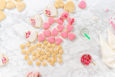 Düz yatıyordu. Sevgililer Günü için pembe ve beyaz kraliyet kremalı kalp şeklinde kurabiyeler..