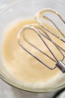 Havuçlu kek için krem peyniri doldurmak için karışımı büyük bir karıştırıcı ile karıştırıyorum..