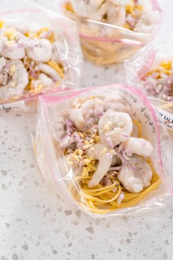 Ev yapımı donmuş karides paketleri plastik yeniden mühürlenebilir poşetlere hazırlanıyor..