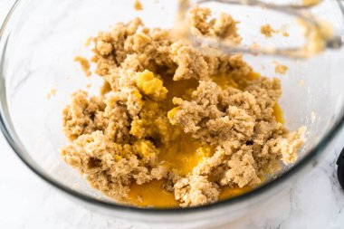 Mixing ingredients with a hand mixer to bake chocolate cookies with chocolate hearts for Valentines Day.