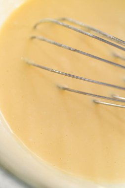 Küçük bir bardakta ıslak malzemeler karıştırmak havuçlu kek yapmak için krem peynirli pasta.