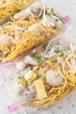 Ev yapımı donmuş karides paketleri plastik yeniden mühürlenebilir poşetlere hazırlanıyor..