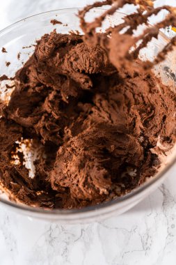 Mixing ingredients with a hand mixer to bake chocolate cookies with chocolate hearts for Valentines Day.