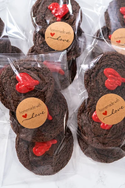 Chocolate cookies with chocolate hearts for Valentines Day packaged in plastic gift bags.