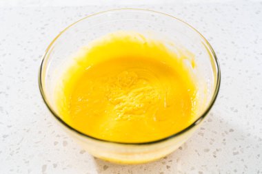 Basit bir vanilyalı kek pişirmek için malzemeleri cam bir kapta çırpma kabıyla karıştırıyorum..