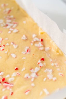 Parşömenle kaplı kare bir cheesecake tavasından şekerleme çıkarmak.