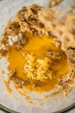 Büyük bir bardaktaki malzemeleri mutfak mikseriyle karıştırıp çikolatalı kurabiyeleri naneli cipsle pişirmek..