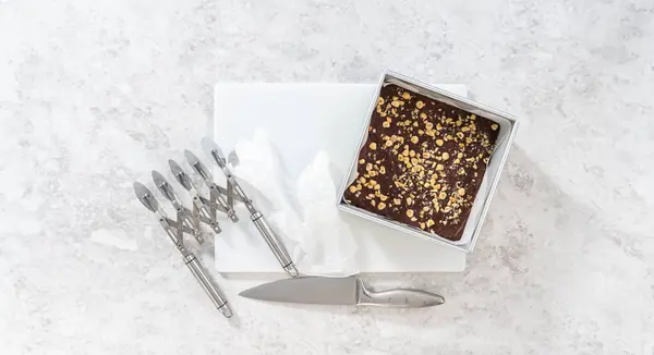 Flat Lay Removing Chocolate Hazelnut Fudge Square Cheesecake Pan Lined — Stock Photo, Image