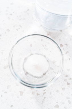 Elma dilimlerinin kahverengileşmesini önlemek için su karışımını hazırlamak için ölçülmüş malzemeler..