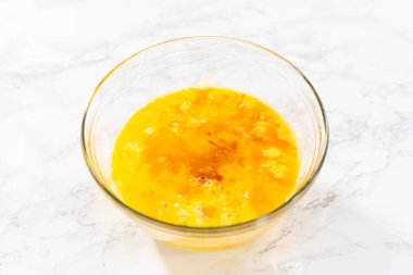 Islak malzemeleri büyük bir bardakta karıştırıp yumurta likörü pişirmek için karıştırıyorum..