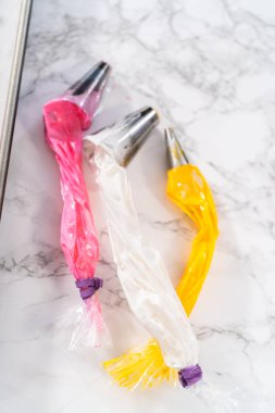 Paskalya kremalı kurabiye pişirmek için parşömen kağıdıyla kaplı pipo poşetleriyle merengi borulamak..