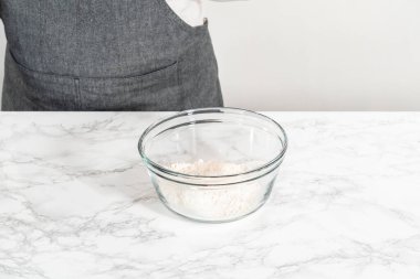 Kuru malzemelerle büyük bir bardakta çırpma kabını karıştırıp mini vanilyalı kekleri ombre pembe tereyağlı kremayla karıştırıyorum..