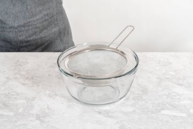 Yeni pişmiş boba incilerini süzgeç süzgecinden akıtıyor..