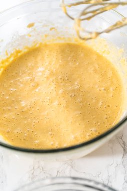 Malzemeleri karıştırıcı ile karıştırarak büyük bir karıştırma kabında yumurta likörü pişirmek..