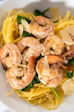 Beyaz seramik kaselerde ıspanaklı sarımsaklı karides makarnası servis ediyorum..