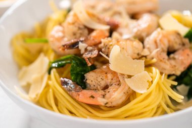 Beyaz seramik kaselerde ıspanaklı sarımsaklı karides makarnası servis ediyorum..