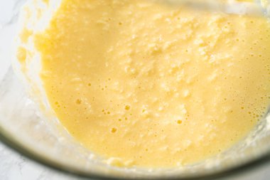 Mini vanilyalı kekler ve ombre pembe kremalı krema pişirmek için büyük bir karıştırma kabında malzemeler karıştırılıyor..