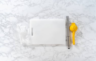 Beyaz bir kesme tahtasının üzerinde taze limon zıp zıp..