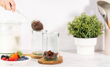 Pouring freshly made mixed berry boba smoothie into a drinking glass.