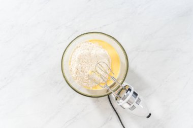 Düz yatıyordu. Limonlu yaban mersinli kek yapmak için büyük bir bardakta karıştırma malzemesi..