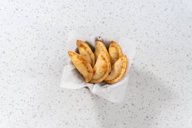 Düz yatıyordu. Mutfak tezgahındaki tavada taze pişmiş vişneli börek var..