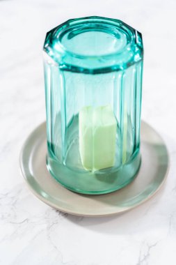 Sıcak bardağın altındaki tuzsuz tereyağı çubuğu.