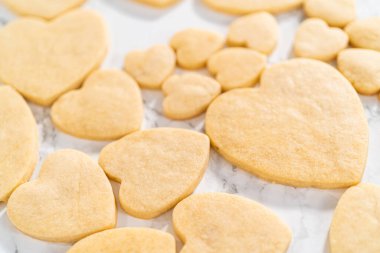 Sevgililer Günü için pembe ve beyaz kraliyet kremalı kalp şeklinde kurabiyeler..