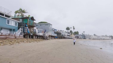 Los Angeles, California, ABD-4 Aralık 2022-POV-Yürürken Miramar Sahili, California kıyılarında bulutlu kış gökyüzü sakin ve yansıtıcı bir atmosfer yaratır..