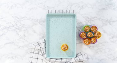 Düz yatıyordu. Mutfak tezgahında badem dilimleriyle süslenmiş taze pişmiş limonlu haşhaşlı çörekler..