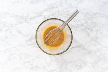 Düz yatıyordu. Limonlu haşhaşlı kek pişirmek için büyük bir bardakta ıslak malzemeler karıştırıyorum..