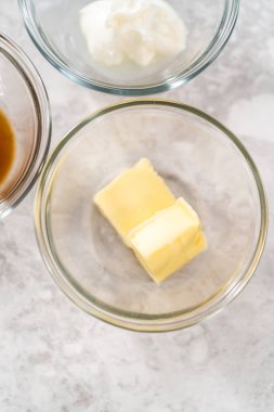 Krem peynirli krema yapmak için cam karıştırma kabında ölçülmüş malzemeler..