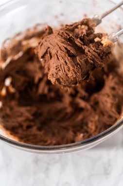 Mixing ingredients with a hand mixer to bake chocolate cookies with chocolate hearts for Valentines Day.