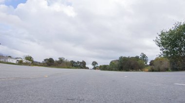 Araç, bulutlu bir kış gününde Morro Bay, Kaliforniya sokaklarında yol alır. Hava karamsar ve sakin bulutlu gökyüzü büyüleyici binalara yumuşak bir ışık ve sessiz