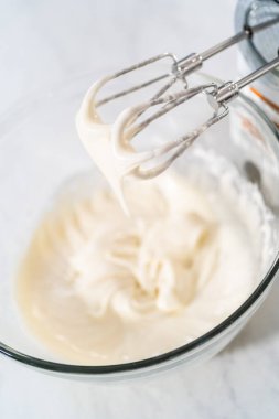 Krem peyniri jöleli yapmak için karışımı büyük bir bardakta karıştırıyorum..