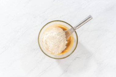 Düz yatıyordu. Islak ve kuru malzemelerle karıştırılmış cam bir kabın içinde çırpılmış beyaz çikolatalı makadamia fındığı..