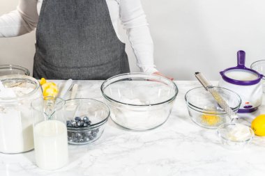 Cam bir kasenin içindeki bileşenleri birleştirmek, bir çırpıcıyla karıştırmak, limonlu-yabanmersinli kek hazırlamak..