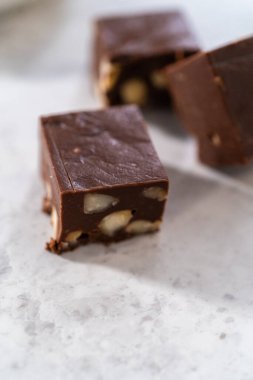 Mutfak tezgahında ev yapımı çikolatalı macadamia şekerleme parçaları..