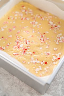 Parşömenle kaplı kare bir cheesecake tavasından şekerleme çıkarmak.