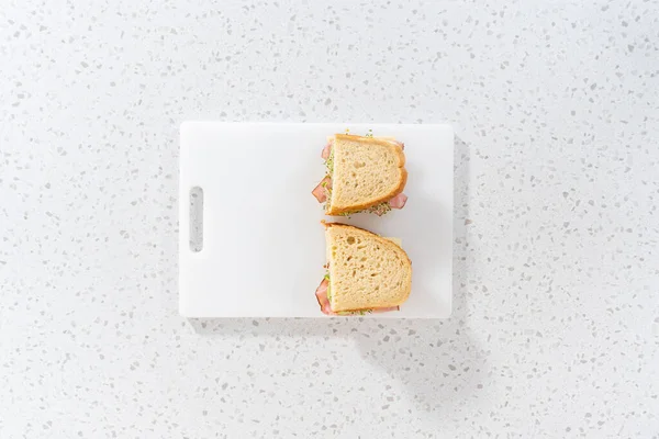 Plat Gelegd Broodjes Ham Komkommer Spruitjes Witte Snijplank Monteren — Stockfoto